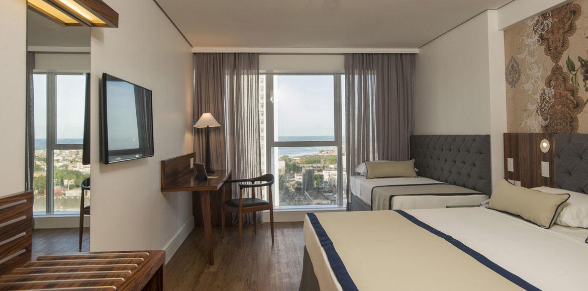 Hotel Luzeiros Recife Exteriör bild The photo shows a modern hotel room. It features two beds with a simple design, one larger and one smaller. There's a large window with sheer curtains, allowing natural light to fill the space and offering a view of the outside. A wooden desk and cha
